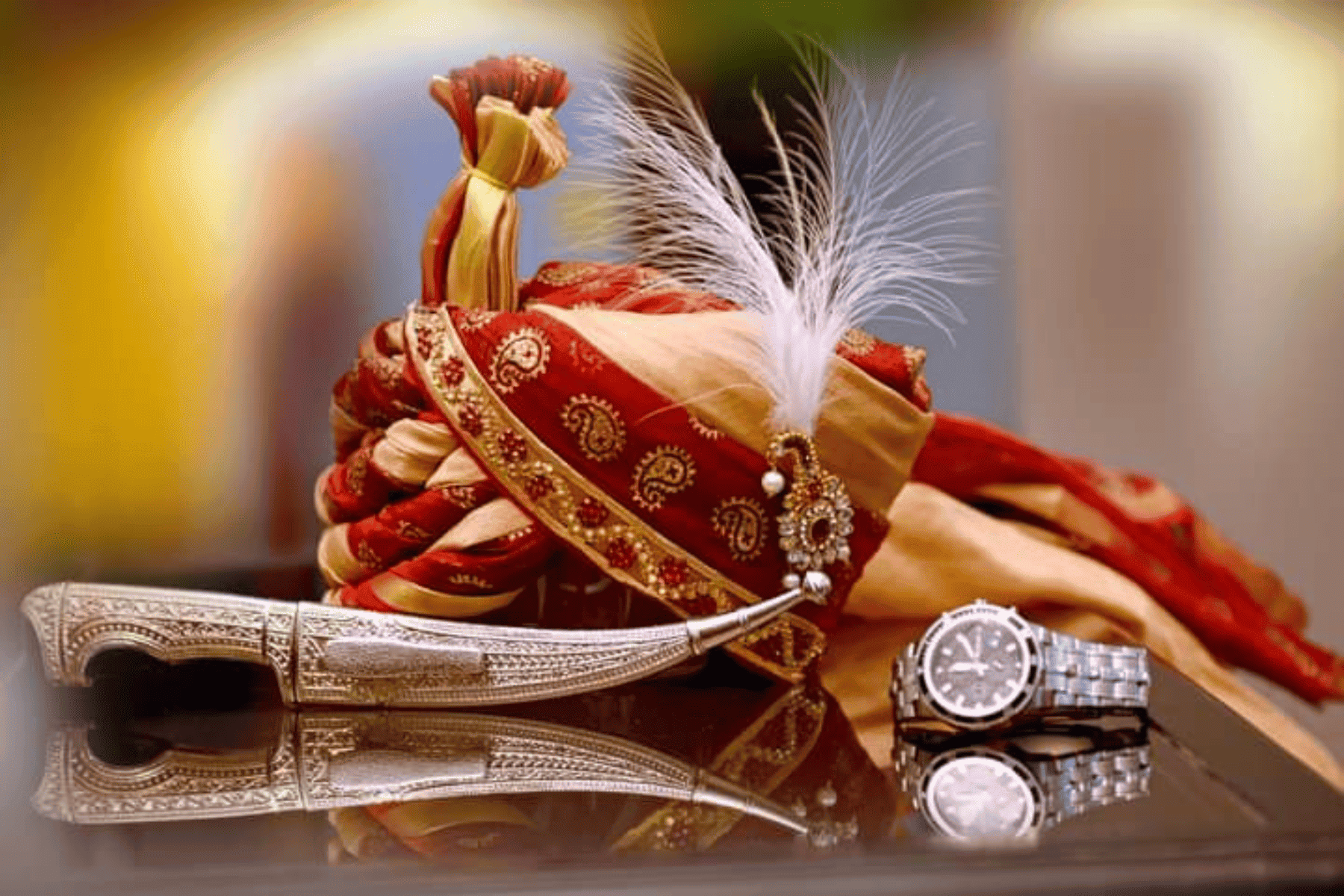 Traditional groom accessories including pagdi, watch, and katar captured in detail