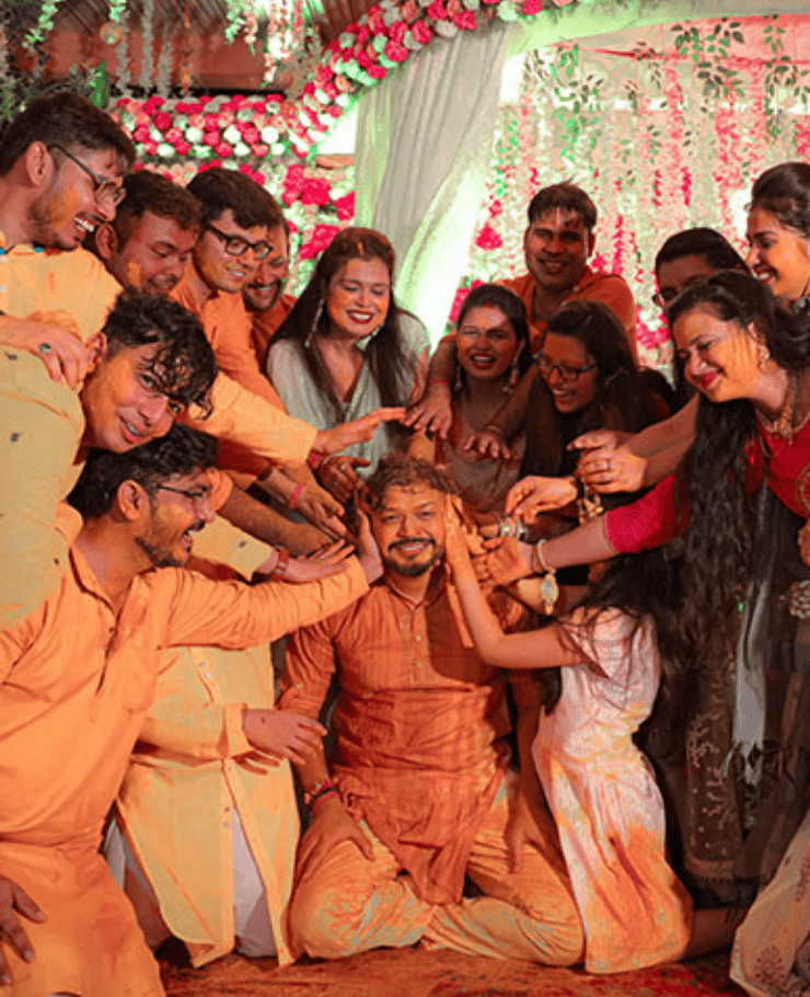 Groom Haldi ceremony with family and friends applying turmeric joyfully