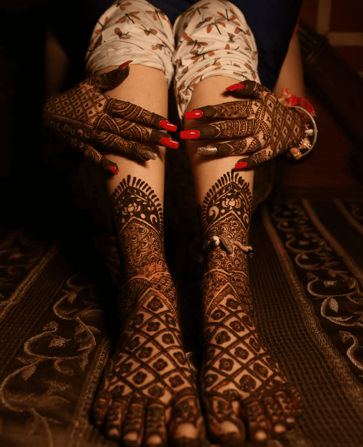 Beautiful bride posing with intricate mehndi design on hands during wedding shoot