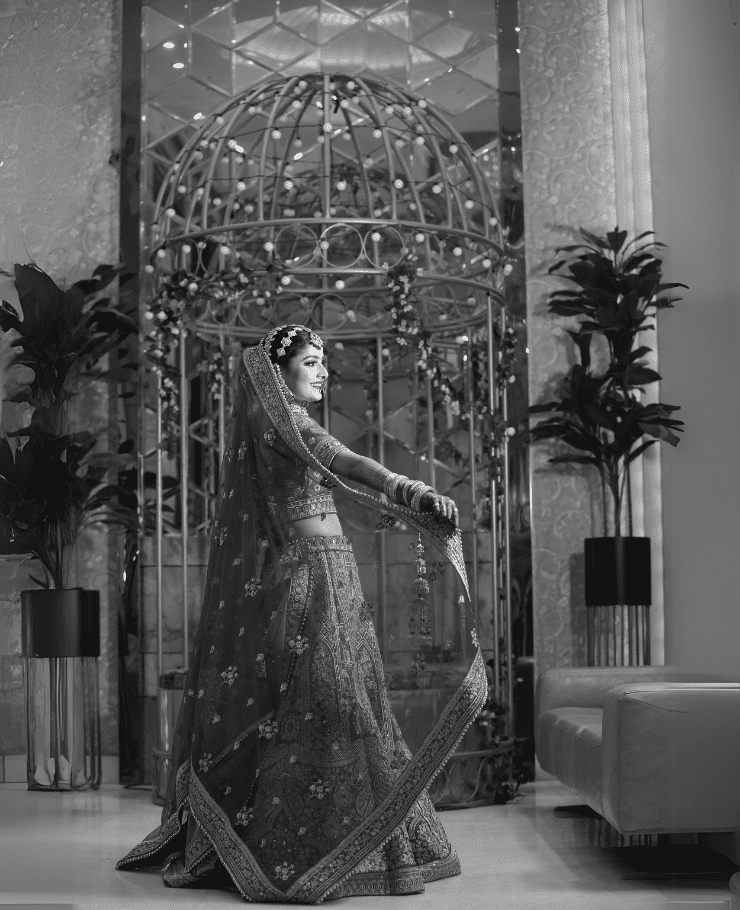 Elegant Indian bride in bridal lehenga posing for black and white theme wedding shoot