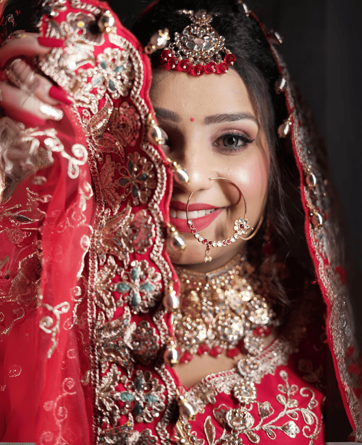 Candid Indian bride in traditional red lehenga smiling on wedding stage
